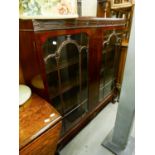 A MAHOGANY DISPLAY CABINET WITH CARVED BLIND FRET FRIEZE, TWO ASTRAGAL GLAZED DOORS, ON STUMP