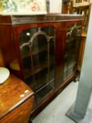 A MAHOGANY DISPLAY CABINET WITH CARVED BLIND FRET FRIEZE, TWO ASTRAGAL GLAZED DOORS, ON STUMP