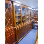 A MODERN YEWWOOD LIBRARY BOOKCASE WITH FOUR GLAZED DOORS TO TOP AND FOUR PANEL DOORS TO BASE (