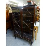 A MAHOGANY BOOKCASE, WITH GADROON BORDER OVER A BLIND FRET FRIEZE, THE PAIR OF ASTRAGAL GLAZED DOORS