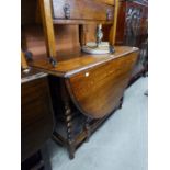 AN OAK OVAL GATE LEG DINING TABLE, ON SPIRAL LEGS