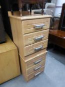 A PAIR OF PINE EFFECT THREE DRAWER BEDSIDE CHESTS WITH METAL BAR HANDLES