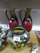 A PAIR OF GREEN AND MAROON GLAZED POTTERY TALL URNS AND A TWO HANDLED VASE (ONE HANDLE MISSING)