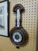 AN EDWARDIAN CARVED WALNUTWOOD ANEROID BAROMETER AND THERMOMETER