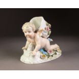 LATE 19th CENTURY GERMAN PORCELAIN POSY HOLDER in the form of a cherub in crawling posture, a basket