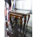 A NEST OF TWO MAHOGANY COFFEE TABLES WITH LEATHER INSET TOPS AND GLASS PROTECTORS