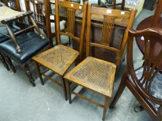 A PAIR OF OAK BEDROOM CHAIRS WITH PIERCED SPLAT BACK AND CANE SEATS (2)