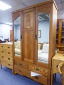 AN EARLY TWENTIETH CENTURY CARVED OAK WARDROBE WITH TWO MIRROR GLAZED DOORS AND THREE DRAWERS