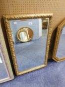 A RECTANGULAR BEVELLED EDGE WALL MIRROR, IN EMBOSSED GILT FRAME, 2?10? HIGH X 1?9? WIDE OVERALL