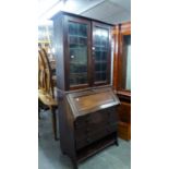 AN EARLY TWENTIETH WALNUT BUREAU BOOKCASE, THE UPPER SECTION ENCLOSED BY TWO LEAD LIGHT DOORS AND