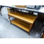 A TEAK TWO TIER COFFEE TABLE, HAVING PULL-OUT SHELVES TO EACH SIDE (51cm high x 90cm wide x 46cm)