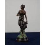 A TWENTIETH CENTURY PATINATED AND COLD PAINTED BRONZE FEMALE FIGURE on combined circular base,