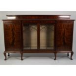 EARLY TWENTIETH CENTURY FIGURED MAHOGANY INVERTED BREAKFRONT DISPLAY CABINET, the shaped top with