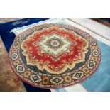 EUROPEAN MACHINE WOVEN CIRCULAR WOOL RUG OF EASTERN DESIGN, with large centre medallion, on a red