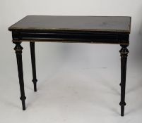 NINETEENTH CENTURY EBONISED AND GILT METAL MOUNTED FOLD-OVER CARD TABLE. The oblong swivel top