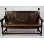 NINETEENTH CENTURY CARVED OAK SETTLE, the three panel back well carved with stylised foliage,