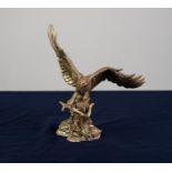 A MODERN COLD CAST RESIN FILLED GILT FINISH 'STERLING SILVER' MODEL OF AN EAGLE,  perched on a