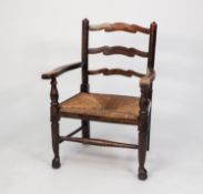 NINETEENTH CENTURY ELM LADDER BACK NURSING OPEN ARMCHAIR WITH LOW RUSH SEAT, enclosed by flat,