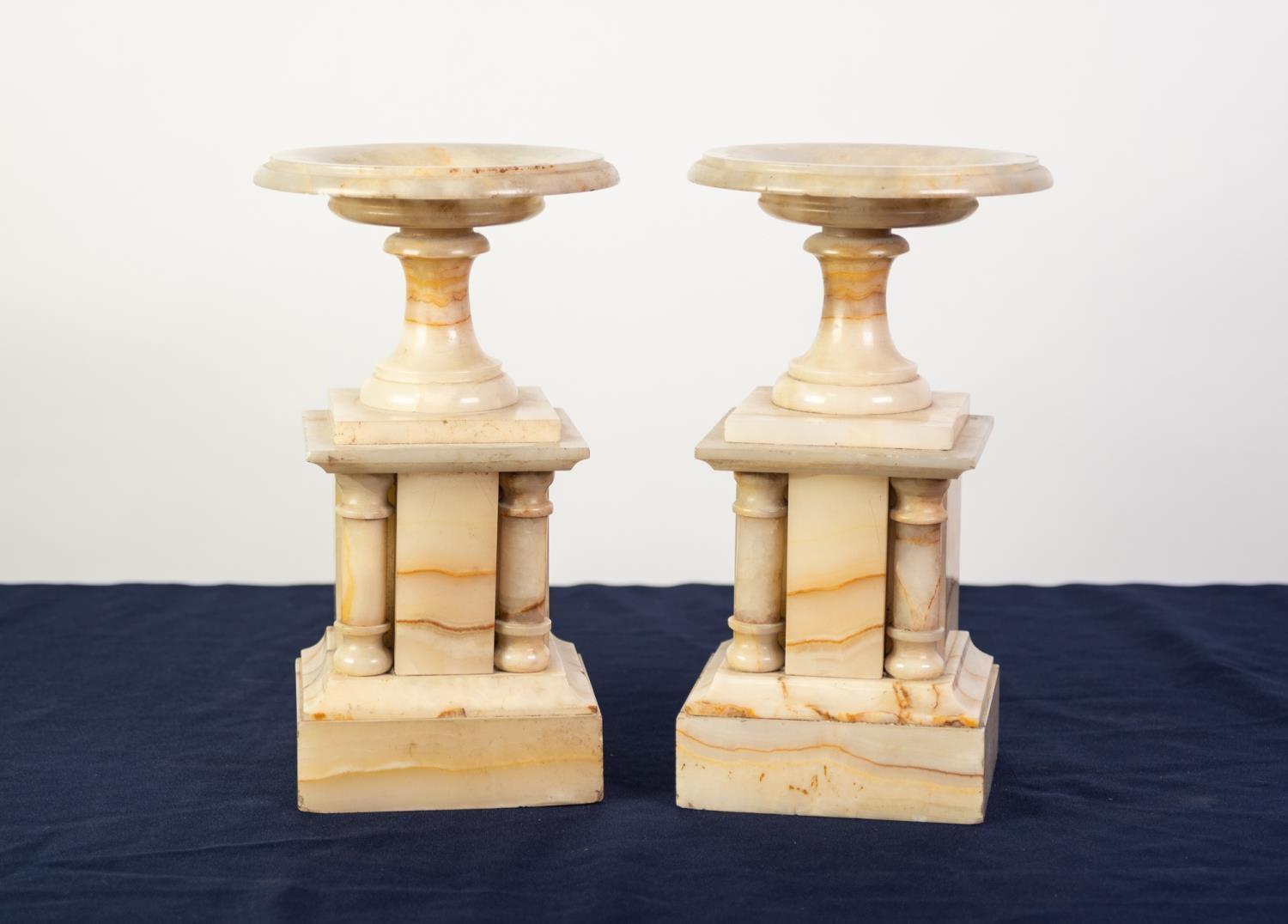 PAIR OF VARIEGATED CREAM ONYX CLOCK SIDE GARNITURES IN TEH FORM OF PEDESTAL DISHES OR VIDE-POCHE,