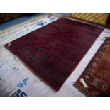 TURKOMAN BOKHARA CARPET, dark crimson with three rows of black stencilled large octagonal guls,