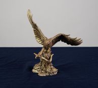 A MODERN COLD CAST RESIN FILLED GILT FINISH 'STERLING SILVER' MODEL OF AN EAGLE,  perched on a