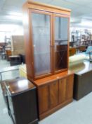 A MAHOGANY DISPLAY CABINET WITH TWO GLAZED DOORS ENCLOSING TWO PLATE GLASS SHELVES, ON AN ADVANCED