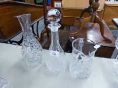 A CUT GLASS SKITTLE SHAPED WINE DECANTER AND STOPPER; A CUT GLASS CARAFE AND A CUT GLASS WATER