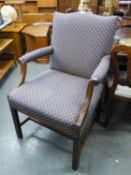 A LARGE UPHOLSTERED ARMCHAIR WITH SCROLL ARMS AND STUD DECORATION, RAISED ON STRAIGHT SUPPORTS