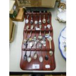 COLLECTION OF EIGHTEEN ELECTROPLATED AND CHROME PLATED SOUVENIR SPOONS ON WOODEN MURAL DISPLAY RACK,