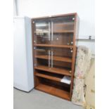 A WOOD EFFECT TALL DISPLAY CABINET, WITH TWO PAIRS OF FRAMELESS GLASS DOORS AND SHELF BELOW AND A