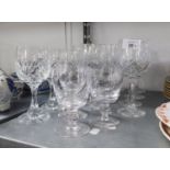 A SET OF EIGHT CUT GLASS TALL WINE GOBLETS, ON PANELLED AND WAISTED STEMS AND STAR CUT CIRCULAR