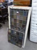 TWO STAINED GLASS PANELS WITH STYLISED FLORAL ROUNDELS, one in white painted window type frame,