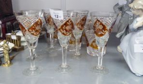 A SET OF SIX CUT GLASS STEM WINES, THE CONICAL BOWLS WITH AMBER STAINED AND FLORAL ENGRAVED PANELS