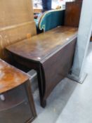 A NINETEENTH CENTURY MAHOGANY GATELEG DINING TABLE WITH SHAPED TOP