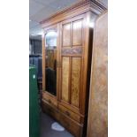 AN EDWARDIAN FLAME MAHOGANY TWO DOOR WARDROBE, ONE DOOR HAVING ARCH-TOP MIRROR WITH CARVING ABOVE,