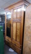 AN EDWARDIAN FLAME MAHOGANY TWO DOOR WARDROBE, ONE DOOR HAVING ARCH-TOP MIRROR WITH CARVING ABOVE,