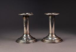 PAIR OF FILLED STERLING SILVER CANDLESTICKS, each with embossed border to the sconce, 4 ½? (11.
