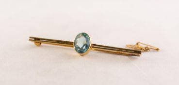 9ct GOLD BAR BROOCH, the centre collet set with an oval blue zircon, with safety chain, 2 1/2in (6.