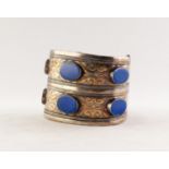 FOREIGN SILVER COLOURED METAL DOUBLE WIDTH BROAD OPEN BANGLE, the top set with six lapis lazuli oval