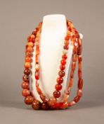 SINGLE STRAND NECKLACE OF ORANGE HARDSTONE GRADUATED ROUND BEADS and a PAIR OF SIMILAR NECKLACES