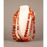 SINGLE STRAND NECKLACE OF ORANGE HARDSTONE GRADUATED ROUND BEADS and a PAIR OF SIMILAR NECKLACES