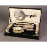 CASED GEORGE V ENGINE TURNED SILVER CLAD SIX PIECE DRESSING TABLE HAND MIRROR AND BRUSH SET BY A & J