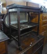 AN OAK TWO-TIER TEA TROLLEY WITH FLAP-TOP,  FORMING A CARD TABLE AND A ROBING MIRROR