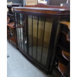 A MAHOGANY DWARF DISPLAY CABINET WITH TWO GLAZED DOORS TO THE BOW FRONT, ON STUMP CABRIOLE SUPPORTS,