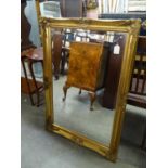 AN OBLONG BEVELLED EDGE WALL MIRROR, IN GILT SWEPT FRAME, 3?6? WIDE