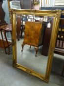 AN OBLONG BEVELLED EDGE WALL MIRROR, IN GILT SWEPT FRAME, 3?6? WIDE