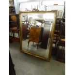 A LARGE BEVELLED EDGE OBLONG WALL MIRROR IN GILT, SWEPT FRAME