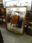 A LARGE BEVELLED EDGE OBLONG WALL MIRROR IN GILT, SWEPT FRAME