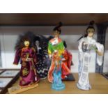 FOUR ELABORATELY DRESSED ORIENTAL FEMALE COSTUME DOLLS AND ANOTHER OF A MONGOLIAN WARRIOR, ALL
