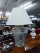 A LARGE POTTERY TABLE LAMP DECORATED WITH EXOTIC BIRDS AND SHRUBS WITH LARGE CREAM SHADE